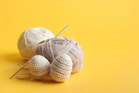 Cute striped pattern crocheted eggs, pastel color with skeins of yarn Foto stock