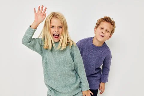Cute stylish children in multi-colored sweaters posing for fun Lifestyle Stock Photos
