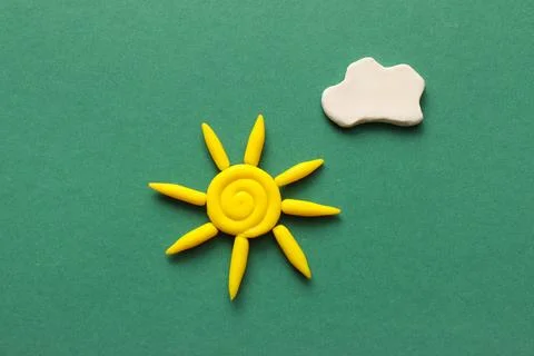 Cute sun and cloud made of plasticine on green background Stock Photos