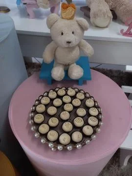 A cute teddy bear and a plate full of treats to celebrate the arrival of babies! Stock Photos