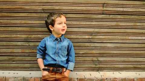 Cute three year old boy posing against wooden house wall Video stock 30146445