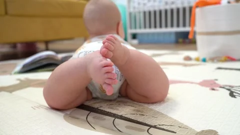Cute tiny bare feet of a Caucasian baby moves his legs. 4k video Stock Footage 266820758