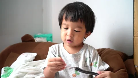 Cute toddler 2 year boy brushing his teeth in the cozy room Stock Footage 137645544