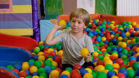 Cute toddler boy, child, playing in colorful balls in children playground Vídeos de archivo 111760686