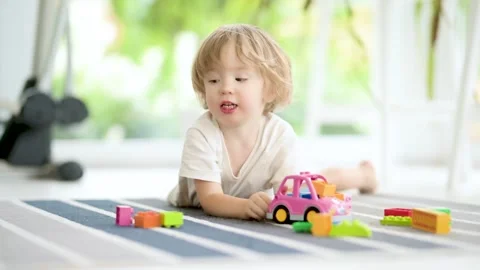 Cute toddler boy playing with lego blocks construction set on the floor at home Stockbeeldmateriaal 271007201