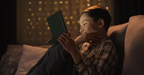 Cute toddler boy using digital tablet watching cartoons at night Stock Footage 243062087
