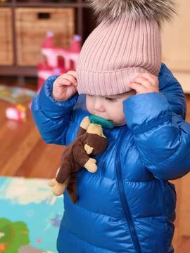 Cute toddler in a bubble coat, hat and with a pacifier 写真素材