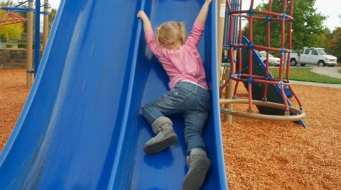 Cute toddler can't seem to make it up the slide Video stock 58636163