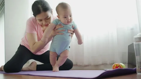 Cute toddler enjoying the first steps with mom while her practicing yoga. Stock Footage 152564342