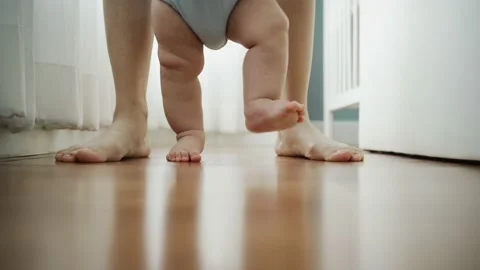 Cute toddler enjoying the first steps with mom. Video stock 156906207