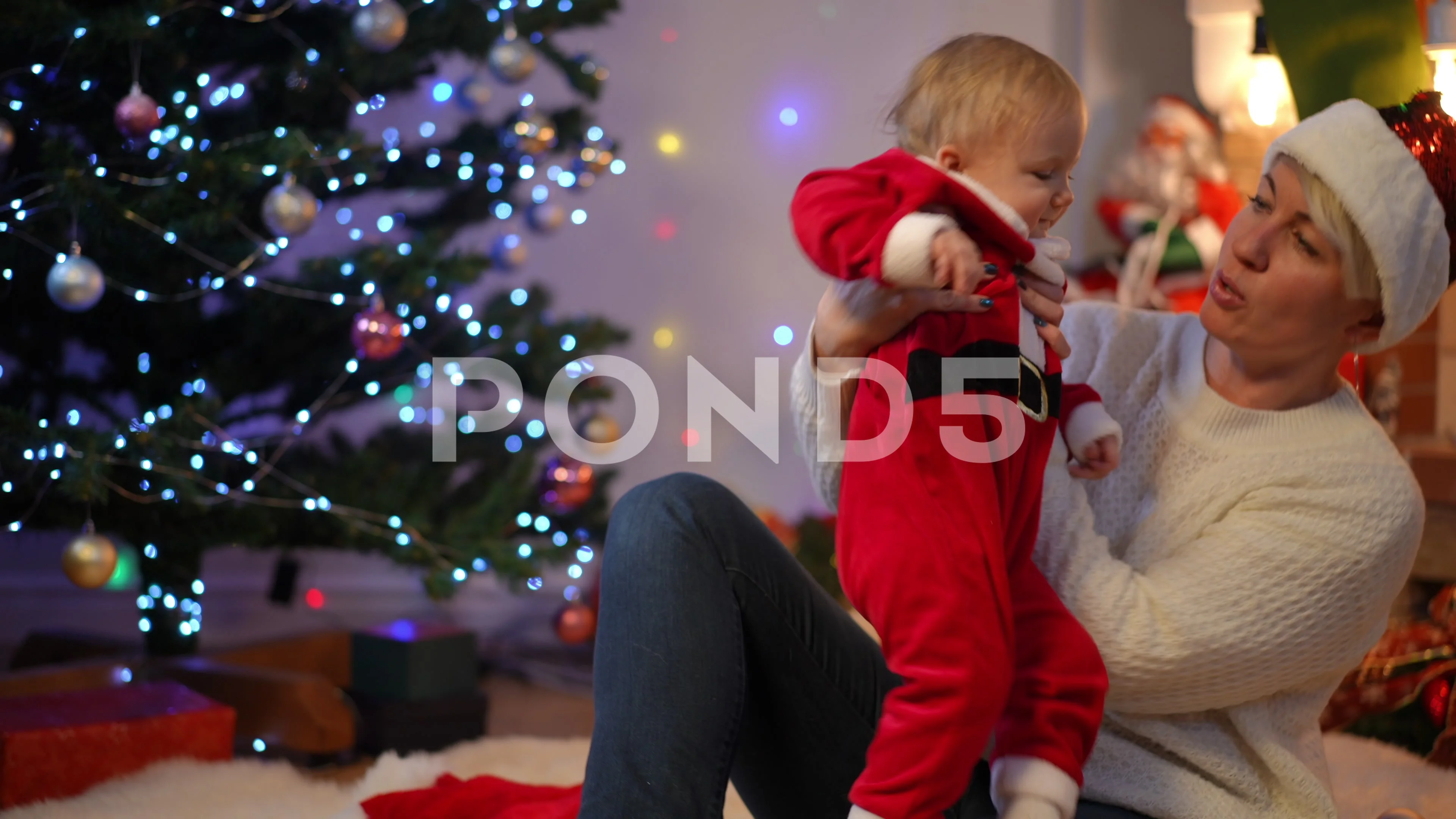 Cute toddler girl in Santa costume enjoying leisure with cheerful aunt on