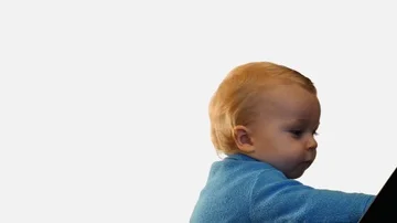 Cute toddler look in screen and pressing notebook button vertical dolly shot Stock Footage 85961826