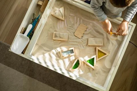 Cute toddler playing self development home kinetic sandbox use Maria Montessori Stock Photos