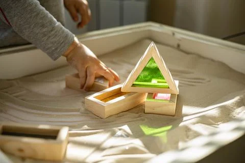 Cute toddler playing self development home kinetic sandbox use Maria Montessori Stock Photos