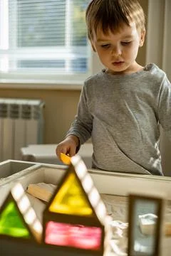 Cute toddler playing self development home kinetic sandbox use Maria Montessori Stock Photos