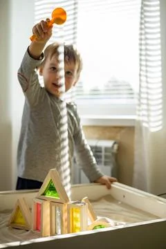 Cute toddler playing self development home kinetic sandbox use Maria Montessori Stock Photos