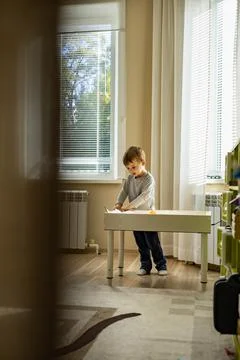 Cute toddler playing self development home kinetic sandbox use Maria Montessori Stock Photos