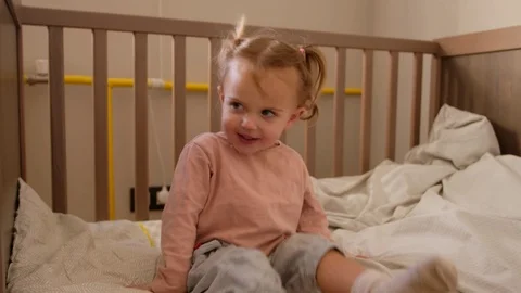 Cute toddler sitting on cot Video stock 126027123