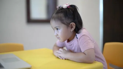 Cute toddler sitting down nicely and paying attention on online class Stock Footage 158966276