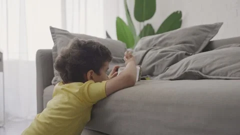 Cute toddler sitting on floor playing with smartphone indoors Stock Footage 246132809
