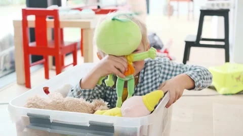 Cute toddler sitting inside a basket plays with puppets Stock-Footage 140581522
