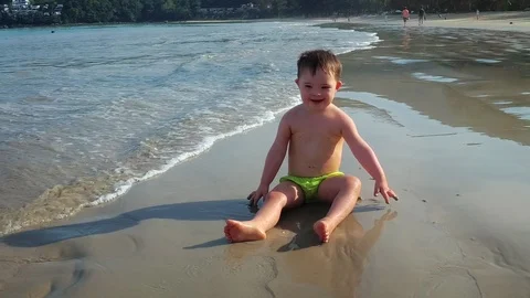 Cute Toddler Splashes and Throws Sand on the Beach in Thailand Видео 97292221