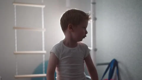 Cute toddler warms up before intensive training in gym Stock Footage 243308926
