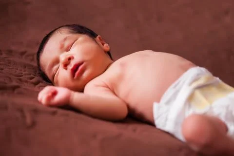 A cute two weeks old newborn baby girl without clothes, naked or nude using a Stock Photos
