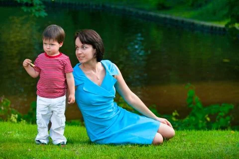 Cute two years old boy with his young mom in park Stock Photos