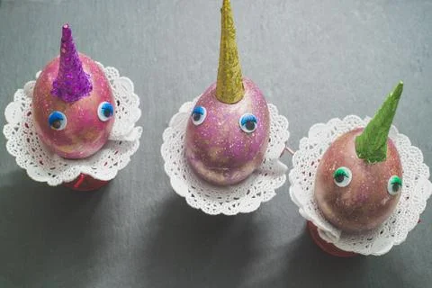 Cute unicorns space easter eggs with colorful horns and toy eyes on black bac Stock-Fotos