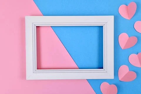 Cute Valentine flat lay with empty white picture frame with paper craft hearts Stock-Fotos
