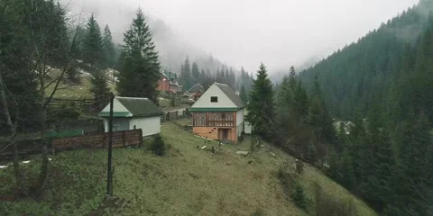 Cute village in cloudy mist with small houses and narrow road Stock Footage 281642875