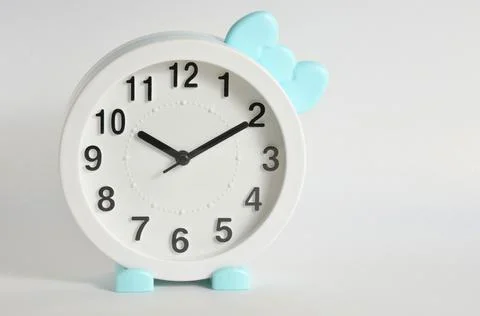 Cute white clock on a white background. Stock Photos