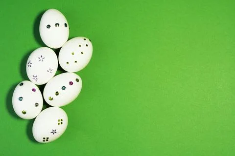 Cute White Easter Eggs Decorated with Tiny Sparkly Gems On Green Background Stock Photos