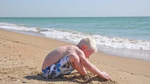 Cute white little boy play with sand on summer tropical beach. Vacation concept. Stock Footage 265870097