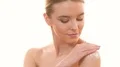 The cute woman applying a cream on the skin on the white background 4k or 4k+ Resolution