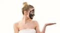 The cute woman with a black face care mask gesturing on the white background 4k or 4k+ Resolution