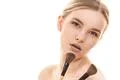 The cute woman with cosmetic brushes on the white background Photo
