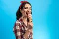 The cute woman eating an ice cream on the blue background Photo