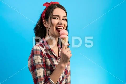 The cute woman eating an ice cream on the blue background Stock Photos