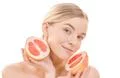 The cute woman holding a grapefruit on the white background Photo