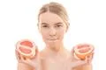 The cute woman holding a grapefruit on the white background Photo