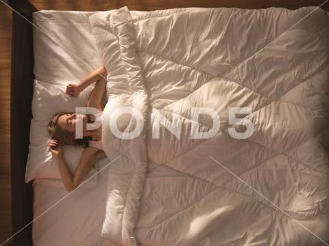 The cute woman lay on the bed and gesture. View from above Stock Photos