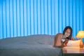 The cute woman lay on the bed and phone. Evening night time Photo