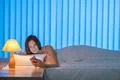 The cute woman lay on the bed and phone. Evening night time Photo