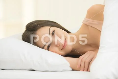 The cute woman lay on the bed Stock Photos
