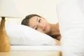 The cute woman lay on the bed with white linens Photo