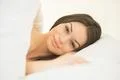 The cute woman lay in the white linens Photo