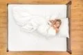 The cute woman lie on the bed. View from above Photo