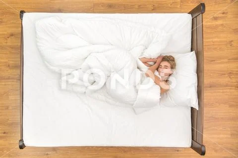 The cute woman lie on the bed. View from above Stock Photos